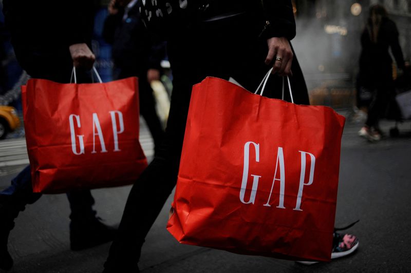 © Reuters. FILE PHOTO: Shoppers carry bags from a Gap store as they walk along Fifth Avenue in the Manhattan borough of New York, U.S., November 20, 2016. REUTERS/Mark Kauzlarich/File Photo