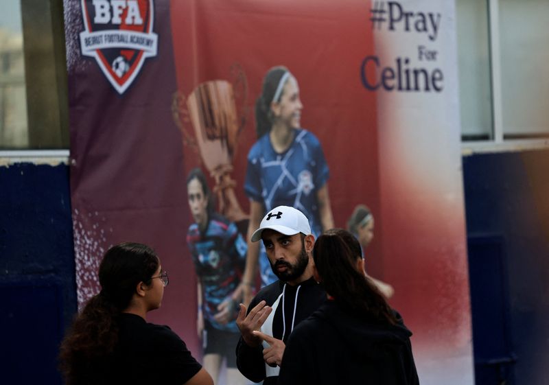 &copy; Reuters. Samer Barbary, coach of Celine Haidar, a 19-year-old footballer who has been left in a medically-induced coma after an Israeli strike near her home in Beirut's southern suburbs left her critically wounded, talks with Celine's teammates at Beirut Football 