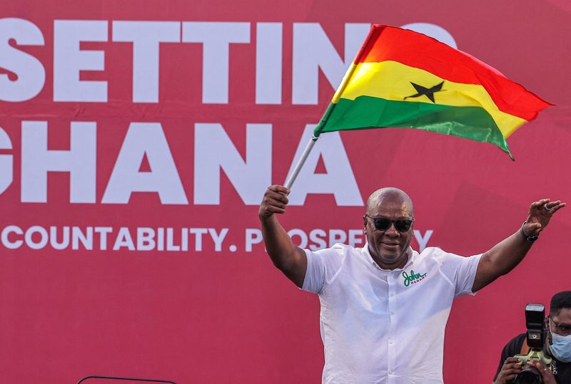 © Reuters. FILE PHOTO: National Democratic Congress (NDC) presidential candidate and former Ghanaian President John Dramani Mahama holds a national flag as he waves to supporters during  his final election campaign rally in Accra, Ghana December 5, 2024.  REUTERS/Zohra Bensemra/File Photo