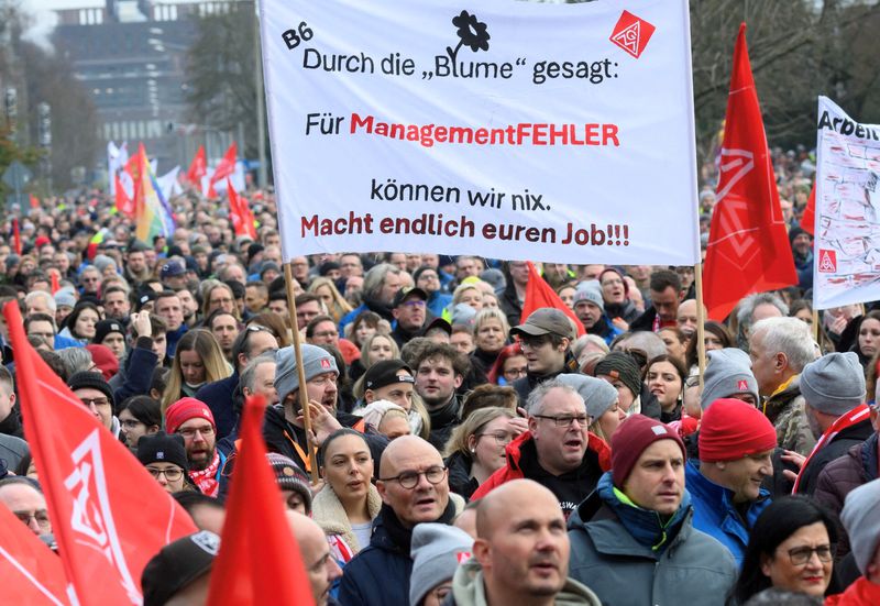 © Reuters. FILE PHOTO: Workers of Europe's largest carmaker Volkswagen AG gather during pay-rise protests on the grounds of VW’s main plant in Wolfsburg, Germany, December 2, 2024. The placard reads „Through the flower said: we are not responsible for management mistakes. Finally do your job !“.    Julian Stratenschulte/Pool via REUTERS/File Photo