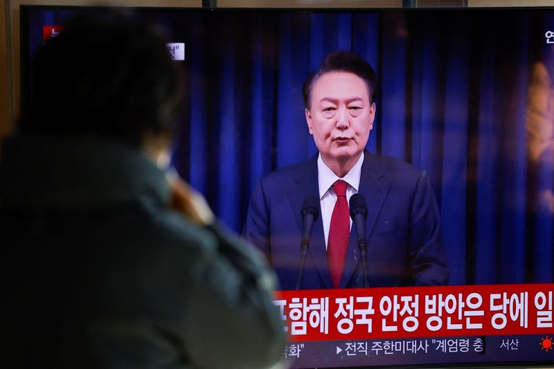 © Reuters. FILE PHOTO: A person watches the broadcast of South Korean President Yoon Suk Yeol delivering a speech to the nation, at a train station in Seoul, South Korea December 7, 2024. REUTERS/Kim Soo-hyeon/File Photo