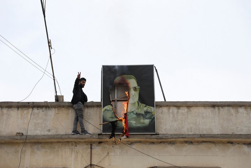 &copy; Reuters. Cartaz com foto de Bashar al-Assad em chamas em Qamishli, Sírian 8/12/2024    REUTERS/Orhan Qereman