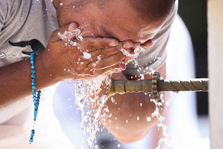 &copy; Reuters. Un turista usa una fontana per rinfrescarsi durante un'ondata di caldo a Sarajevo, Bosnia-Erzegovina, 13 agosto 2024. REUTERS/Amel Emric