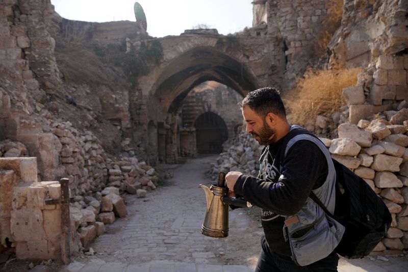 © Reuters. A man walks with coffee in the Old City, after Syrian rebels announced that they have ousted Bashar al-Assad, in Aleppo, Syria, December 9, 2024. REUTERS/Karam al-Masri