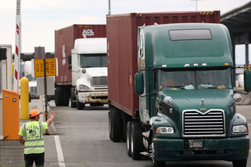 &copy; Reuters. FILE PHOTO: A worker directs traffic after trucks are loaded with shipping containers at the Port Authority of New York and New Jersey in, Newark, New Jersey, U.S., September 30, 2024. REUTERS/Caitlin Ochs/File Photo