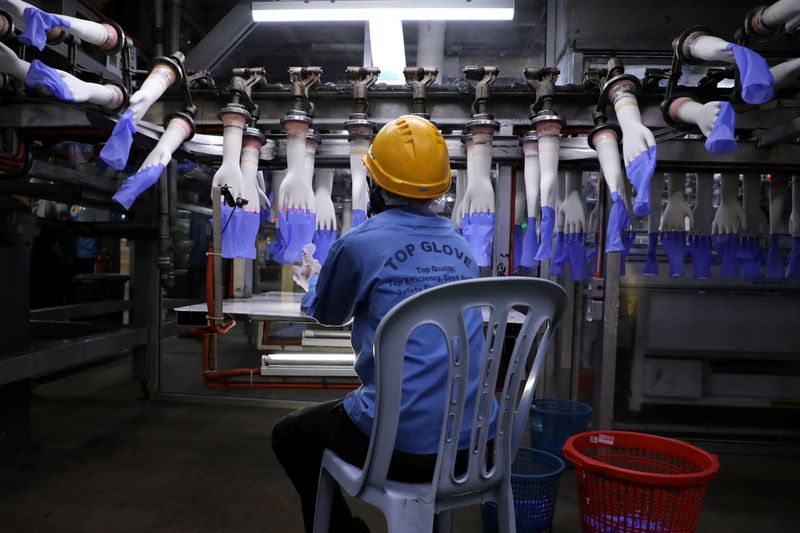 &copy; Reuters. FILE PHOTO: A worker inspects newly-made gloves at Top Glove factory in Shah Alam, Malaysia August 26, 2020. REUTERS/Lim Huey Teng/File Photo