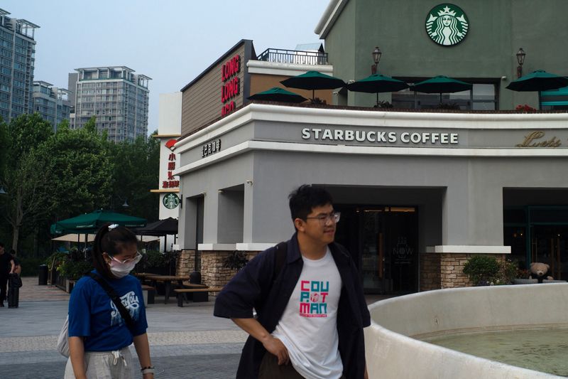 &copy; Reuters. FILE PHOTO: People walk past a Starbucks coffee shop in Beijing, China, May 22, 2024. REUTERS/Tingshu Wang/File Photo