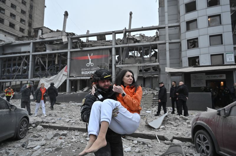 © Reuters. A police officer evacuates a woman from a building heavily damaged by a Russian missile strike, amid Russia's attack on Ukraine, in Zaporizhzhia, Ukraine December 10, 2024. REUTERS/Stringer