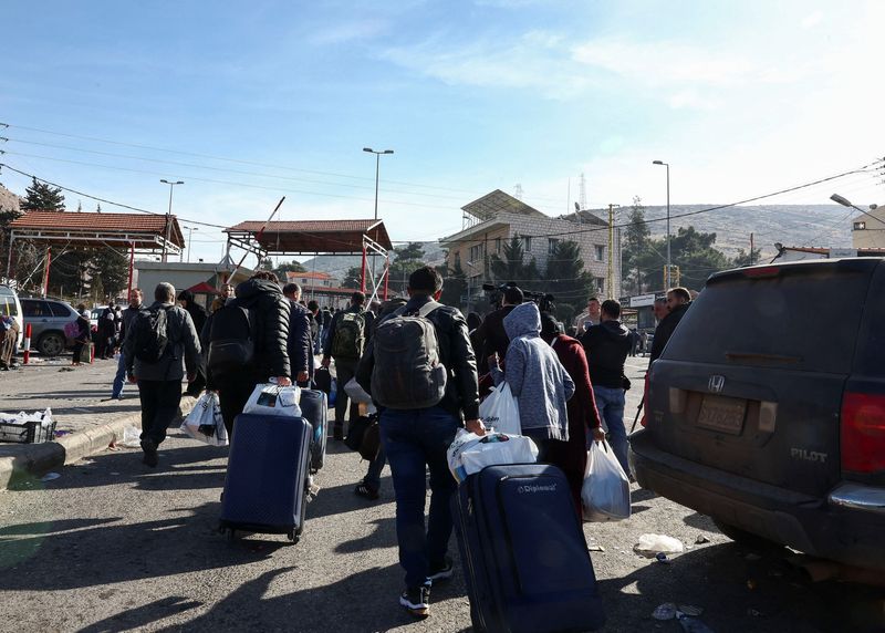 &copy; Reuters. People walk with belongings as they attempt to cross into Syria, at the Masnaa border crossing between Lebanon and Syria, after Syrian rebels ousted Syria's Bashar al-Assad, December 10, 2024. REUTERS/Emilie Madi