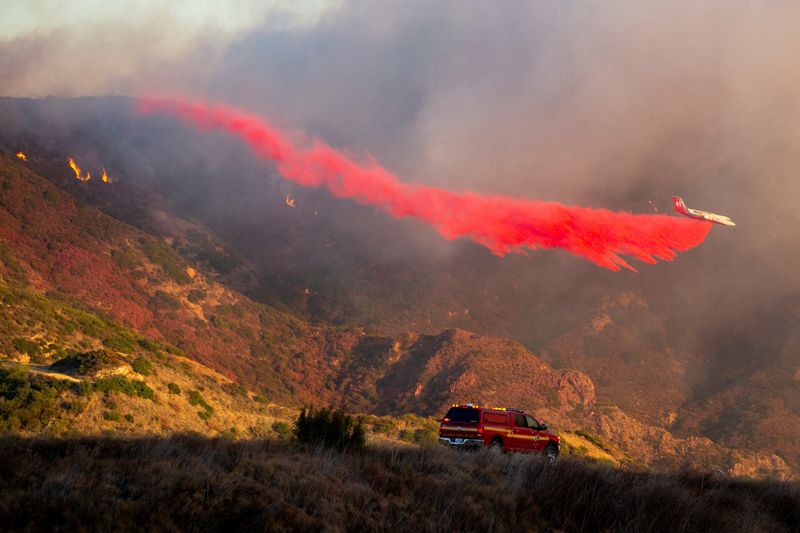 © Reuters. An air tanker drops retardant as the Franklin Fire burns in Malibu, California, US, on December 10, 2024. REUTERS/Ringo Chiu    