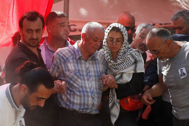 © Reuters. Mehmet Suat Eygi, father of Aysenur Ezgi Eygi, a Turkish-American activist killed in the Israeli-occupied West Bank, is helped by relatives as he walks by his daughter's grave during her funeral at a cemetery in Didim, in the western Aydin province, Turkey, September 14, 2024. REUTERS/Dilara Senkaya/File Photo