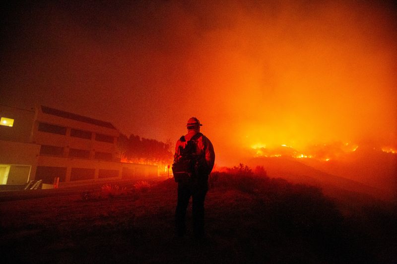 © Reuters. A firefighter watches as the Franklin Fire burns in Malibu, California, U.S., December 10, 2024. REUTERS/Ringo Chiu