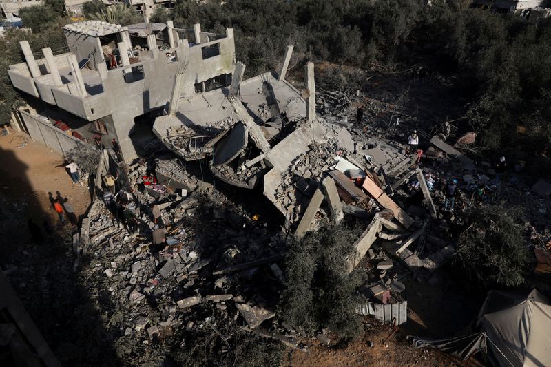 © Reuters. Palestinians gather at the site of an Israeli strike on a house, amid the ongoing conflict between Israel and Hamas, in Nuseirat, central Gaza Strip, December 11, 2024. REUTERS/Abd Elhkeem Khaled