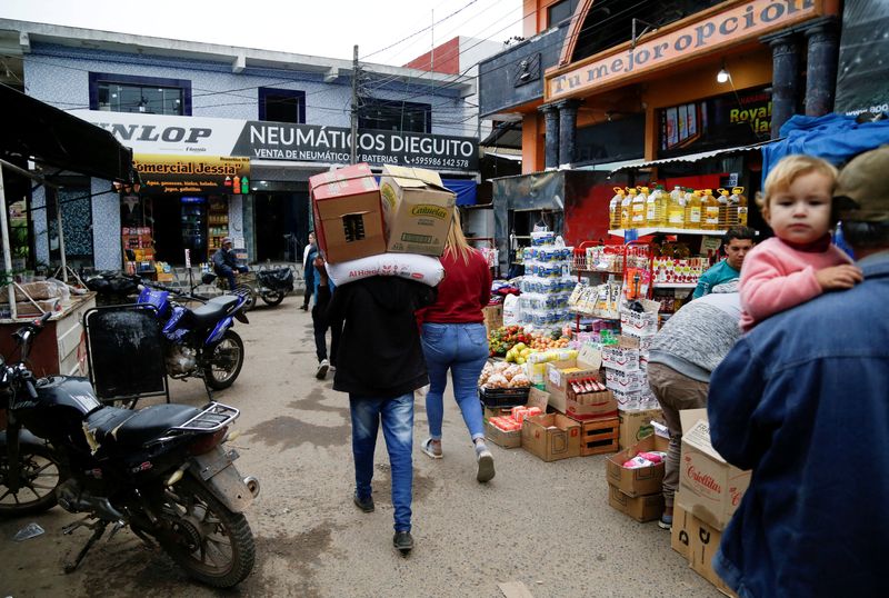 &copy; Reuters. Homem carrega mercadorias em mercado perto da fronteira com a Argentina, em Nanawa, Paraguain16/05/2024nREUTERS/Cesar Olmedo