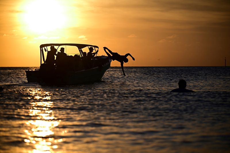 &copy; Reuters. Turistas saltam de uma lancha, no Parque Nacional Los Roques, Venezuelan31/10/2024nREUTERS/Stringer