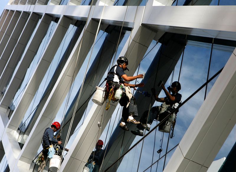 © Reuters. Workers clean the glass windows of an office building in central Sydney July 6, 2009. REUTERS/Daniel Munoz/File Photo