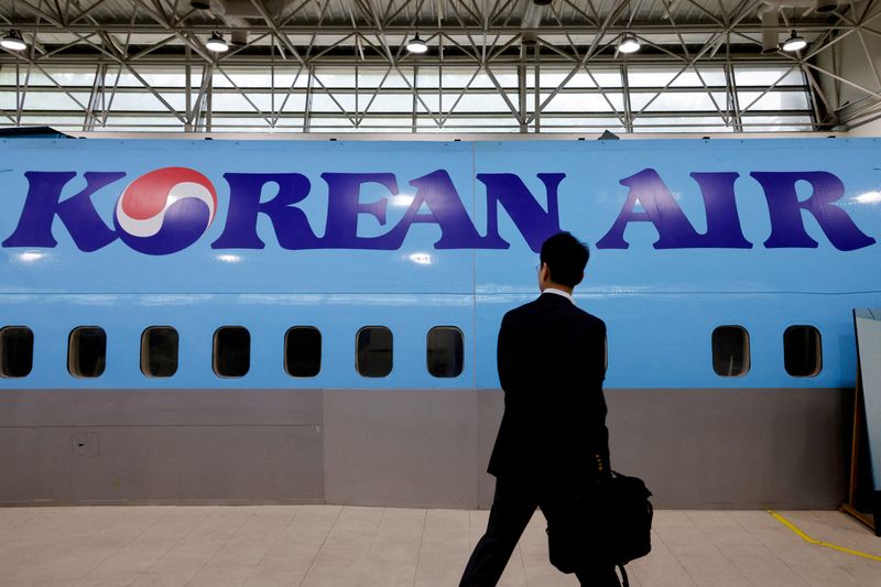 © Reuters. FILE PHOTO: A man walks next to the logo of Korean Air airlines during an organised media tour, at the company's Cabin Crew Training Center in Seoul, South Korea, June 27, 2024. REUTERS/Kim Soo-hyeon/File Photo