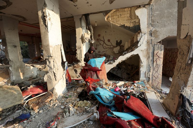 © Reuters. A Palestinian inspects damage at the site of an Israeli strike on a house, amid the Israel-Hamas conflict, at the Nuseirat refugee camp in the central Gaza Strip, December 12, 2024. REUTERS/Ramadan Abed 