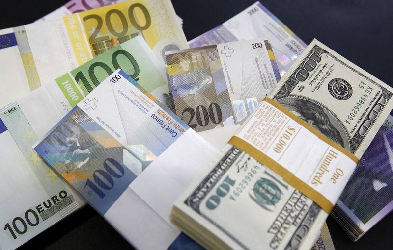 &copy; Reuters. Pile di banconote di euro, dollari statunitensi e franchi svizzeri esposte in una banca di Berna, Svizzera, 15 agosto 2011. REUTERS/Pascal Lauener