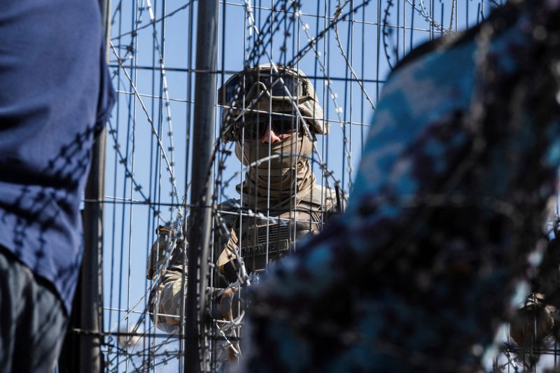 &copy; Reuters. FILE PHOTO: A Texas law enforcement officer stands guard at the border as migrants cross from Mexico into El Paso, Texas, U.S., March 22, 2024.  REUTERS/Justin Hamel/File Photo