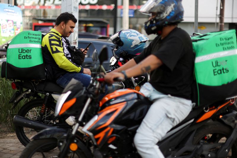 © Reuters. FILE PHOTO: Delivery drivers for Uber Eats rest while they wait for food orders as Mexico proposes a labor reform for drivers and delivery workers using applications like Uber, Didi and Rappi, officials said, in Mexico City, Mexico October 16, 2024. REUTERS/Gustavo Graf/File Photo