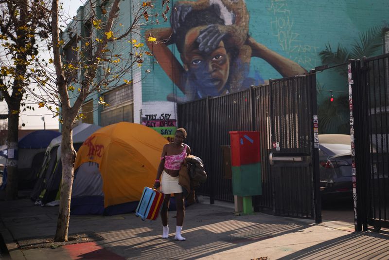 © Reuters. A person carrying a suitcase walks down a street in Skid Row, Los Angeles, California, U.S., December 9, 2024. REUTERS/Daniel Cole