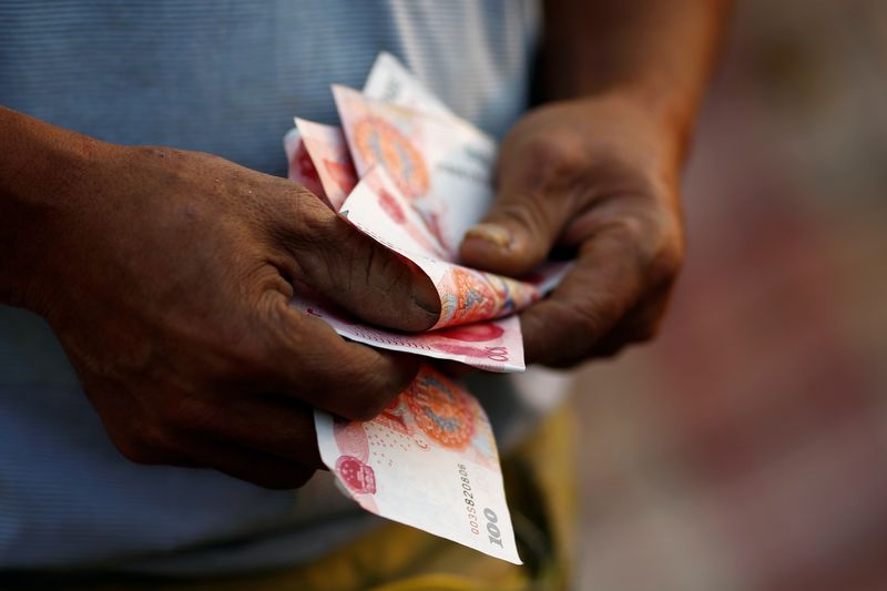 &copy; Reuters. FILE PHOTO: A man counts money as he poses for a picture in Beijing, China, September 21, 2016.   REUTERS/Thomas Peter/File Photo