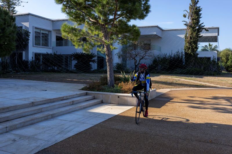 © Reuters. Cyclist Bassel Soufi visits the summer resort of ousted Bashar al-Assad as he tours a part of his daily training in Burj Islam near Latakia, Syria, December 13, 2024. REUTERS/Umit Bektas