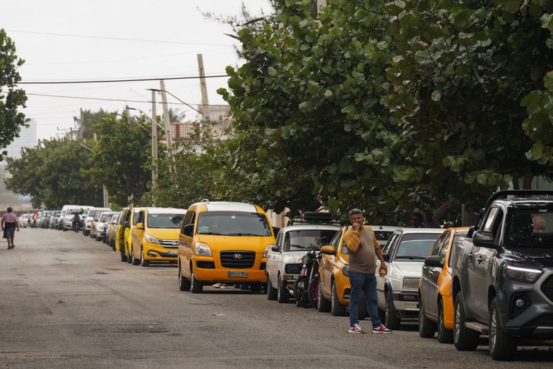 &copy; Reuters. A driver checks the line as he waits for gasoline in Havana, Cuba, December 13, 2024. REUTERS/Alexandre Meneghini