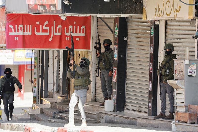 © Reuters. Palestinian security forces take positions during clashes with gunmen in the camp in Jenin in the Israeli-occupied West Bank on December 14, 2024. Photograph: Raneen Sawafta/Reuters. 