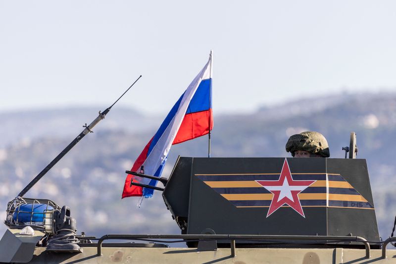 © Reuters. A Russian soldier rides on an infantry fighting vehicle part of a Russian military convoy heads towards Hmeimim air base in Syria's coastal Latakia, Syria, December 14, 2024. REUTERS/Umit Bektas