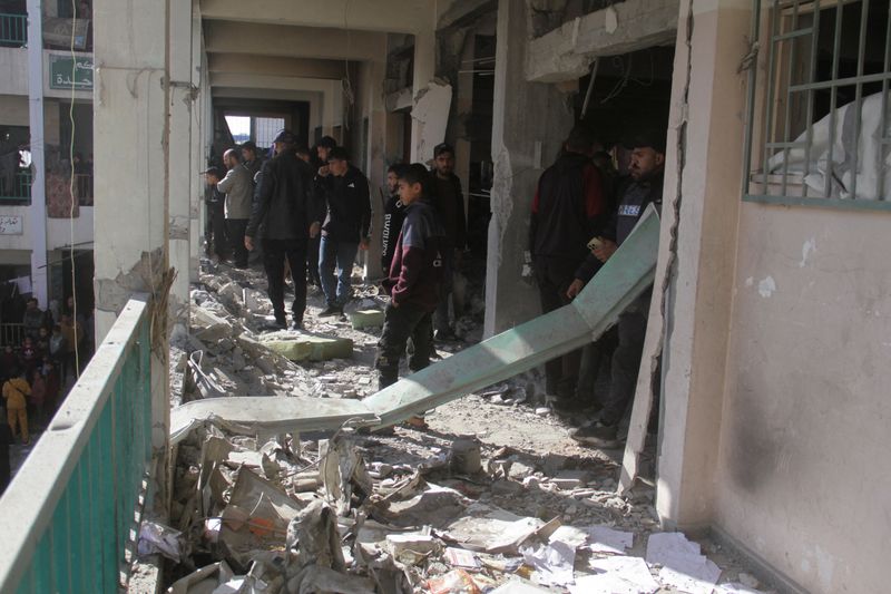 © Reuters. Palestinians walk amid the rubble, inspecting the damage, following an Israeli strike on a school sheltering displaced people, amid the Israel-Hamas conflict, in Gaza City December 14, 2024. REUTERS/Mahmoud Issa