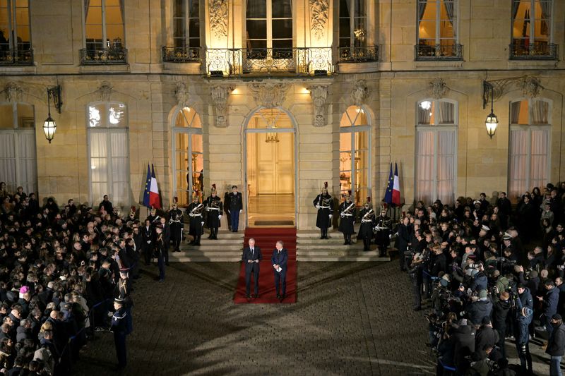 © Reuters. FILE PHOTO: France's outgoing Prime Minister Michel Barnier speaks next to newly-appointed Prime Minister and President of the Democratic Movement (MoDem) party Francois Bayrou during the handover ceremony at the Hotel Matignon in Paris on December 13, 2024. BERTRAND GUAY/Pool via REUTERS/File Photo