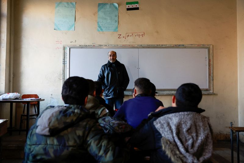 © Reuters. Students sit in a classroom at a school early in the morning after authorities announced the reopening of schools following the ouster of Syria's Bashar al-Assad, in Damascus, Syria, December 15 2024. REUTERS/Ammar Awad