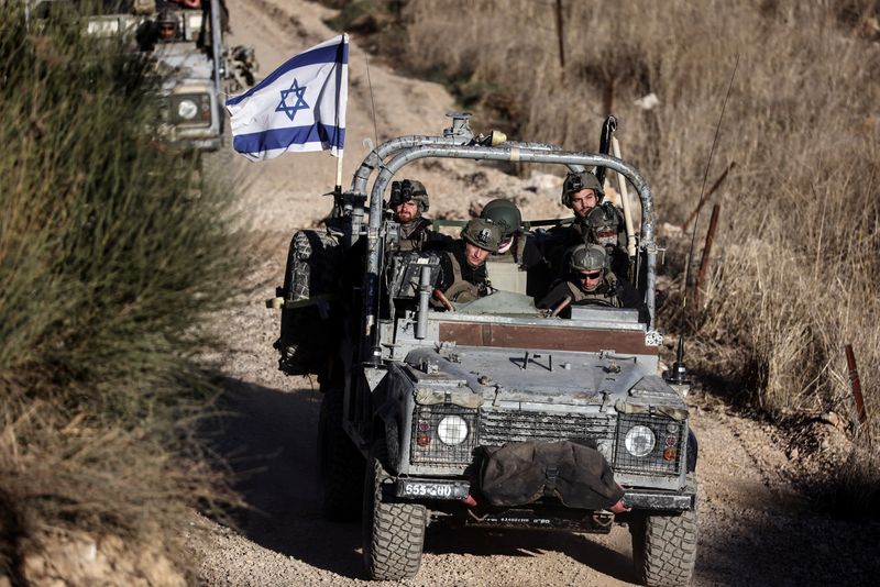 © Reuters. Israeli military vehicles drive through Syria near the ceasefire line between the Israeli-occupied Golan Heights and Syria, seen from Majdal Shams in the Golan Heights, December 15, 2024. REUTERS/Jamal Awad