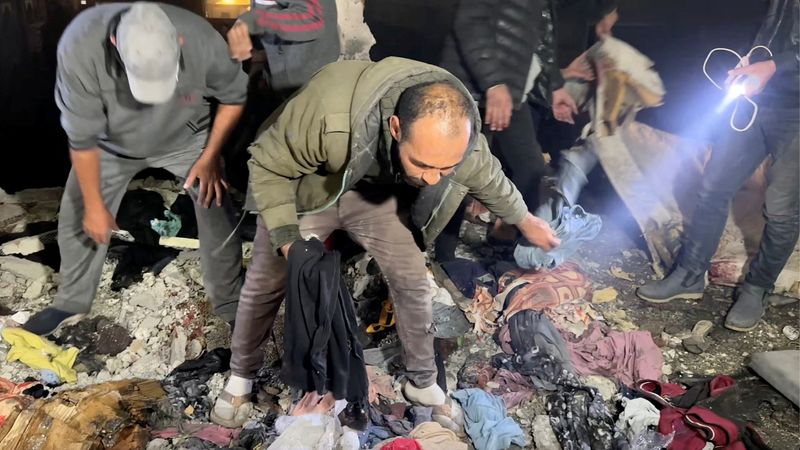 © Reuters. Palestinians check the site of an Israeli strike on a school sheltering displaced people, amid the Israel-Hamas conflict, in Khan Younis in the southern Gaza Strip December 15, 2024. in this screengrab taken from a video. Reuters TV/via REUTERS