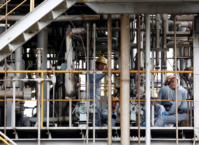 © Reuters. FILE PHOTO: Workers repair facilities at a chemical factory at the Keihin industrial zone in Kawasaki, Japan September 12, 2018. REUTERS/Kim Kyung-Hoon/File Photo