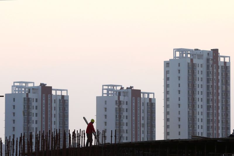 © Reuters. FILE PHOTO: A worker stands on scaffolding at a construction site against the backdrop of residential buildings in Huaian, Jiangsu province, China, October 18, 2018. Picture taken October 18, 2018. REUTERS/Stringer/File Photo