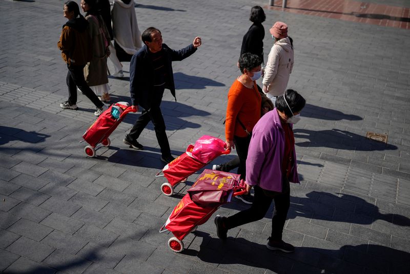 © Reuters. FILE PHOTO: People walk with their shopping trolleys at the main shopping area in Shanghai, China, March 14, 2023. REUTERS/Aly Song/File Photo