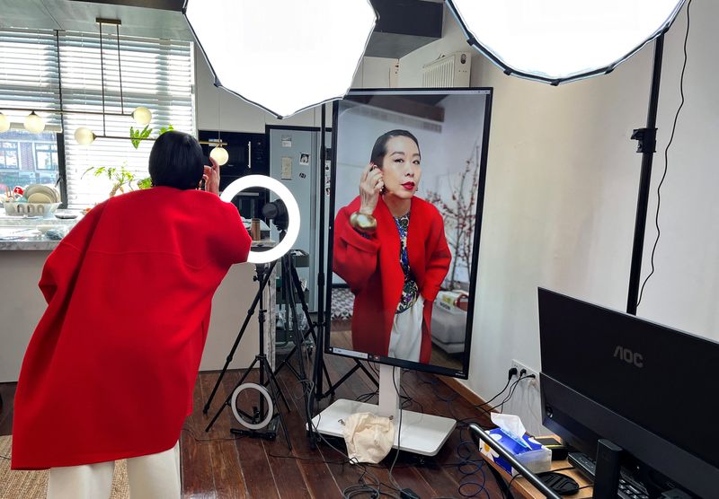 © Reuters. Influencer Tera Feng prepares before hosting a livestream sales session on the social media platform Xiaohongshu, at her apartment in Shanghai, China December 16, 2024. REUTERS/Casey Hall