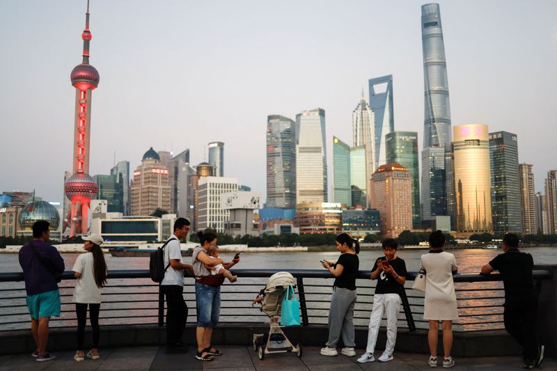 © Reuters. FILE PHOTO: People enjoy themself on the Bund near the financial district of Pudong during the sunset hour, in Shanghai, China September 27, 2024. REUTERS/Tingshu Wang/File Photo