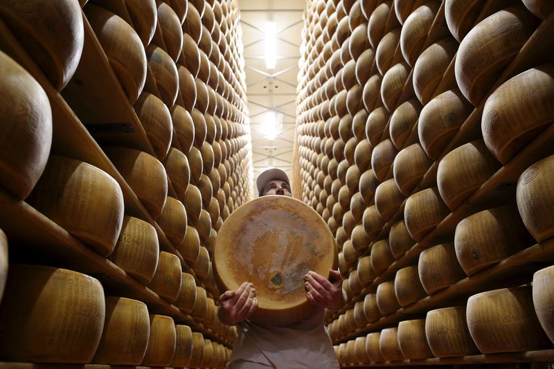 &copy; Reuters. Operaio porta una forma di parmigiano fresco dallo scaffale del magazzino della cooperativa lattiero-casearia 4 Madonne Caseificio dell'Emilia a Modena, Italia, 16 febbraio 2016. REUTERS/Alessandro Bianchi