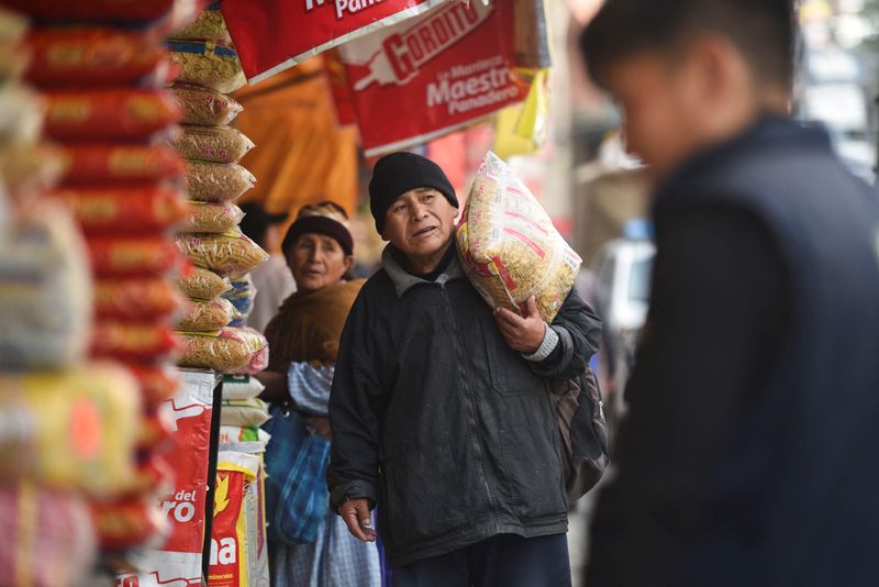 © Reuters. A man carries a bag of noodles at a market, in La Paz, Bolivia December 13, 2024. REUTERS/Claudia Morales