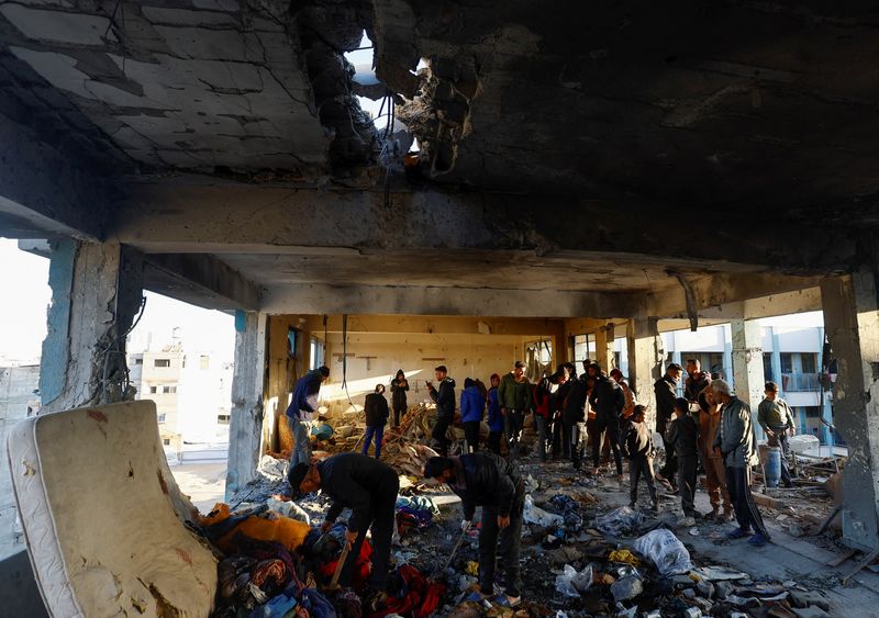 © Reuters. Palestinians inspect the damage in the aftermath of an Israeli strike on a school sheltering displaced people, amid the Israel-Hamas conflict, in Khan Younis in the southern Gaza Strip December 16, 2024. REUTERS/Mohammed Salem