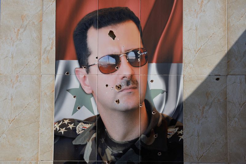 &copy; Reuters. FILE PHOTO: An image of Syria's Bashar al-Assad is damaged by bullet holes, as fighters of the ruling Syrian body inspect the damage at a military site, in the aftermath of an Israeli strike according to Syrian Observatory for Human Rights, after fighters