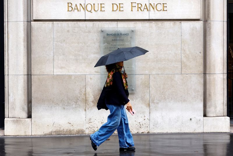 &copy; Reuters. FILE PHOTO: A woman holding an umbrella walks past the Bank of France "Banque de France" building in Paris, France, September 25, 2024.  REUTERS/Abdul Saboor/File Photo