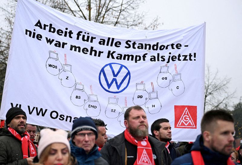 © Reuters. FILE PHOTO: Employees of Volkswagen AG march for higher wages during a 'warning strike' of Germany's IG Metall metalworkers' union, in Osnabrueck, Germany, November 6, 2024. The placard reads, “Jobs for all VW sites - there has never been more fight than now”. REUTERS/Teresa Kroeger/File Photo