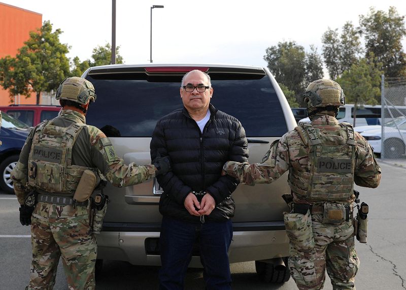 © Reuters. U.S. Immigration and Customs Enforcement officers detain drug lord Osiel Cardenas Guillen, who was deported and turned over to Mexican authorities in Tijuana December 16, 2024, as he pictures in this undated photo. U.S. Immigration and Customs Enforcement/Handout via REUTERS 