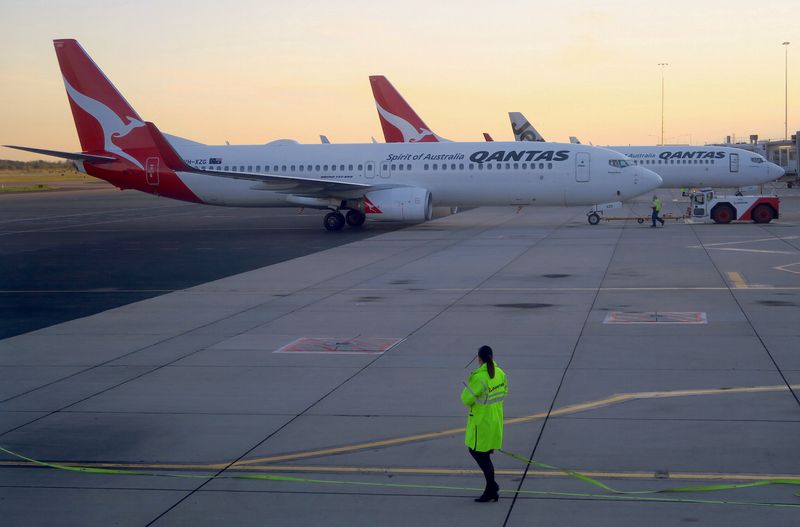 © Reuters. FILE PHOTO: Workers can be seen near Qantas Airways, Australia's national carrier, Boeing 737-800 aircraft on the tarmac at Adelaide Airport, Australia August 22, 2018. REUTERS/David Gray/File Photo