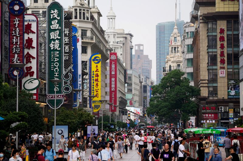 &copy; Reuters. Persone camminano lungo la Nanjing Pedestrian Road, una delle principali aree commerciali, in vista della festa del National Day, a Shanghai, Cina, 26 settembre 2023. REUTERS/Aly Song